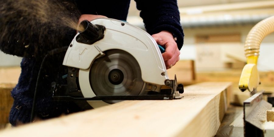 Hombre enseñando como cortar madera gruesa con sierras circulares